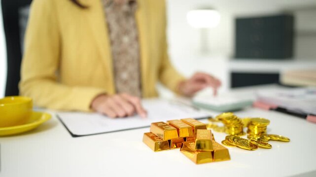 Financial professional calculates gold investment returns manages wealth plans finances using calculator documents secure prosperity office desk smart asset allocation
