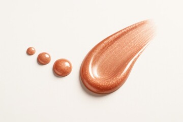 Pink gold lip gloss droplets leading to glossy swipe like a comet tail cosmetic smear