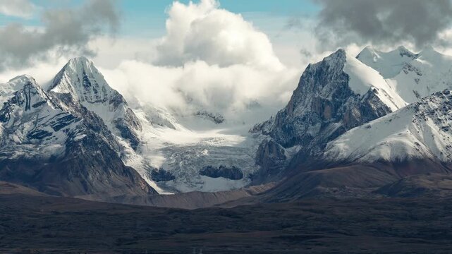 4K time lapse footage of beautiful snow covered mountains with moving rolling clouds like snow slide, in Shigatse, Tibet, China. Travel concept.