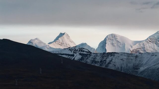 4K time lapse footage of beautiful snow covered mountains with moving clouds background, Kula Kangri snow mountain is the highest peak in Lhoka (Shannan) Prefecture, Tibet, China. Travel concept.