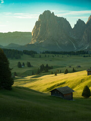 Beautiful sunrise with fields, cottages and mountains. Alpe di Siusi, Dolomites, Italy