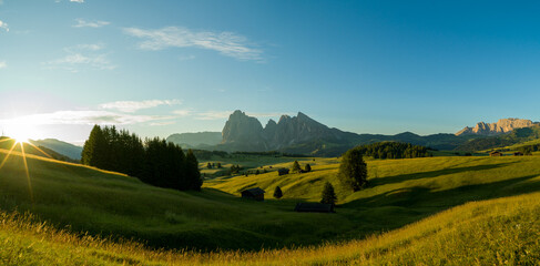 Beautiful sunrise with fields, cottages and mountains. Alpe di Siusi, Dolomites, Italy