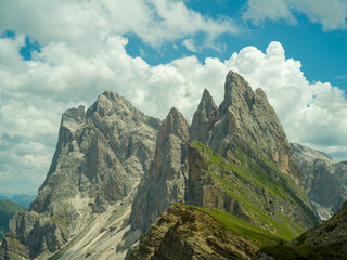 Spectacular view of Seceda ridgeline in the Dolomites, Italy. Dramatic limestone peaks rising above vibrant green slopes under a bright summer sky &mdash; a breathtaking natural masterpiece.