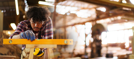 Carpenter measuring wooden works with ruler and level tool.