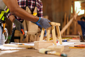 African American carpenters inspecting wood and reviewing documents.