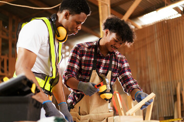 African American carpenters inspecting wood and reviewing documents.
