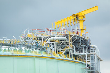 Oil refinery with large storage tanks and industrial pipelines.