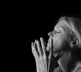 woman praying with hands together on grey black background with people stock image stock photo