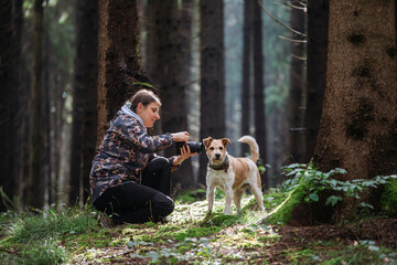 Woman traveler photographer taking photo using camera during autumn trip to mountains and forest