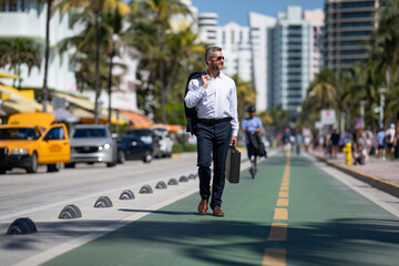 Businessman walking confidently in the city. Businessman walking down the street. Handsome businessman walking on way to the office. Confident entrepreneur businessman walking outdoors. © Volodymyr