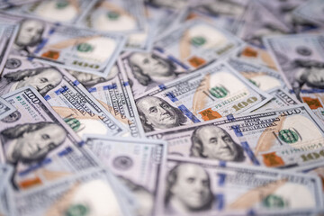 Money background with dollar cash bills. Texture of US cash. 100 USD banknotes in cash. American hundred-dollars notes. Pattern of US dollars for finance concept. Cash in selective focus.