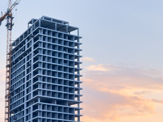 House under construction, unfinished skyscraper against the backdrop of sunset, construction of a new house for a banner, for advertising. High quality