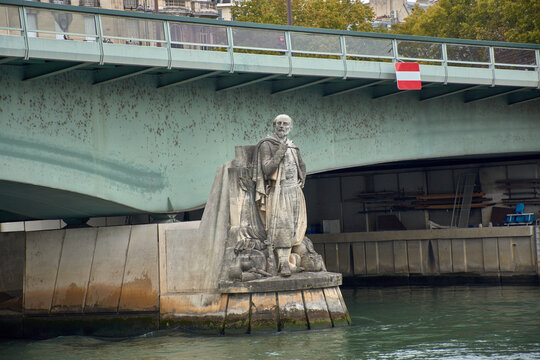 Zouave statue under the Pont de l Alma in Paris with a pedestal in the water and a metal bridge in an urban setting