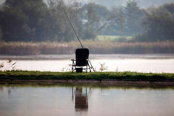 Place of a fisherman with fishing rod into the fog