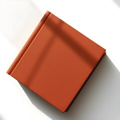 a closed brown book with a blank cover on a table