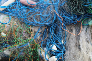 Colorful tangled fishing nets and ropes in close-up view. Detail texture of marine equipment used by fishermen, symbolizing traditional fishing life and coastal industry.
