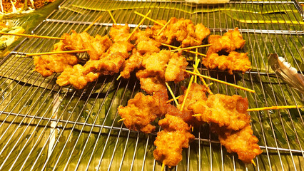 Savory Skewers: A delectable display of golden crispy fried pork skewers arranged neatly on a bed...