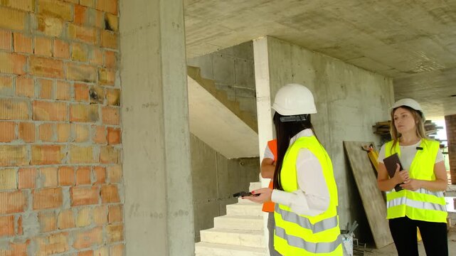 Engineers and construction worker inspect areas during shift. Project managers discuss objectives and results with contractor exchanging views