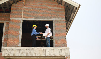 Architects and engineers work together to assess the progress of construction of houses in the...