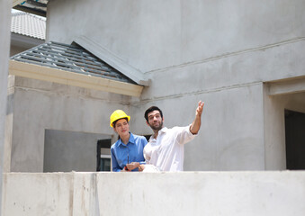 Female engineers and architects stand in front of a construction site, discussing their work, and...