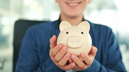 Cheerful man holds a beige piggy bank in an office, wearing a blue shirt. Smiling male embodies the concept of financial planning, savings, and future investments with happiness. - Powered by Adobe