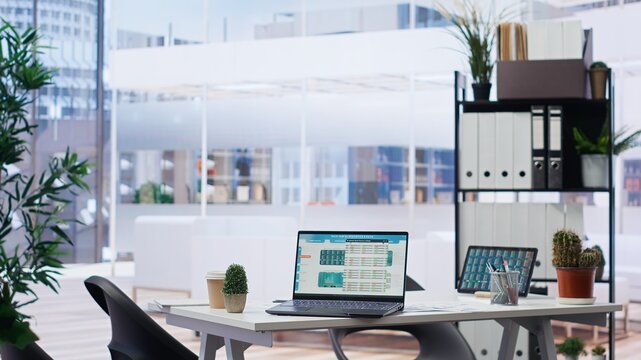 Empty financial department with stock portfolio on laptops and paperwork files filled with marketing charts. Panning shot of forex exchange indices on notebook device screen