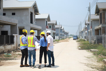 A group of civil engineers discussed and inspected the construction of houses according to...