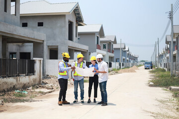A group of civil engineers discussed and inspected the construction of houses according to...