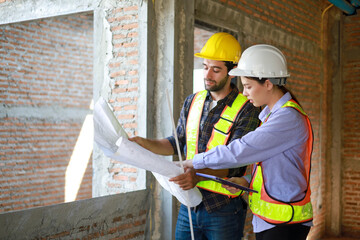 Male and female engineers discuss, inspect, and construct houses in the village. They are...