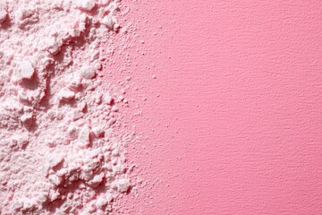Fototapeta premium Close-up of pink powder on a pastel pink background, showcasing texture and color contrast for artistic use