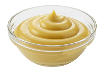 Swirl of yellow mustard in a clear glass bowl isolated, condiment for hot dogs and sandwiches, no background