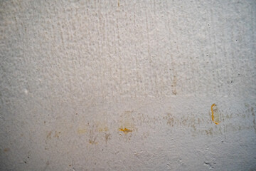 Textured white wall with subtle stains and markings.