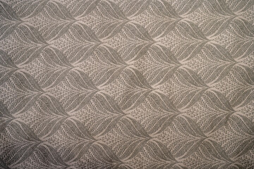 Intricate gray leaf pattern on textured fabric.