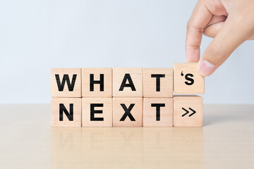 What's next?, business concept. Next step of work, plan, strategies, vision, project implementation, new opportunities and execution. Putting wooden cubes with What's next? and forward arrow symbols