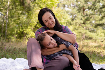 40-year-old mother and her daughter are having fun in park. The beauty of nature, family scenes, outdoor recreation. Summer vacation or weekend getaway. Happy family concept.