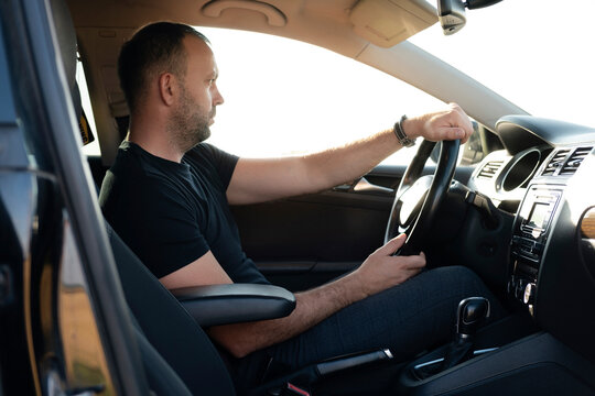The man behind the wheel is not wearing a seatbelt. Safe driving concept.
