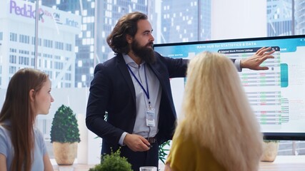 Financial advisor presents detailed stock market analysis to clients on big screen, helping them make informed investment decisions. Broker in office providing family with financial analysis, camera B