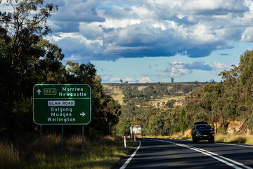 Green roadside sign with directions on B84 and Ulan Road on trip down Australian highway