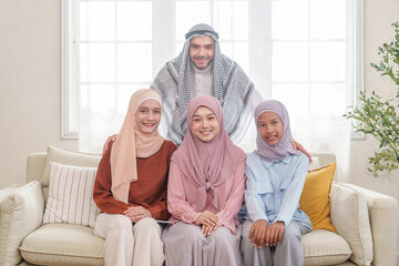portrait of happy muslim family in traditional clothes in living room,posing to camera