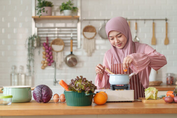 muslim woman in hijab prepare fresh vegetables and fruits to cook healthy food in the modern kitchen