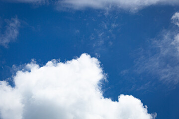 Clear blue sky background with soft white clouds, representing freshness, peace, and natural beauty,