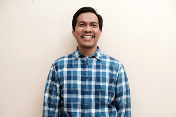 Southeast Asian man wearing flannel shirt standing and smiling expression happy, on white isolated...