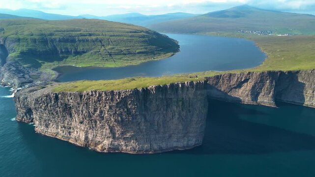 Lake Sorvagsvatn, known for its dramatic cliffs and stunning views, offers a captivating landscape in the Faroe Islands. Explore the vibrant greenery and serene waters.