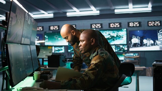 Team of military officers in command center look at intel folder files on enemy battle formation. Intelligence corps colleagues read mission case file to collect data on opponents strategy, camera B