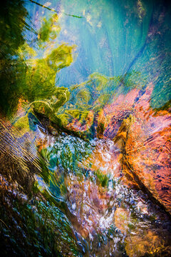 Abstract blend of light and water over river stones