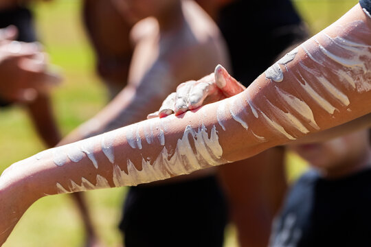 Detail of Aboriginal person applying ochre paint to skin before ceremony
