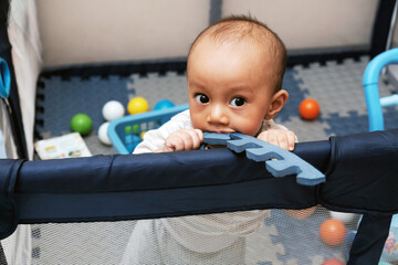 Cute little boy 11 months old playing on the mat with her toys, baby care, stock photo