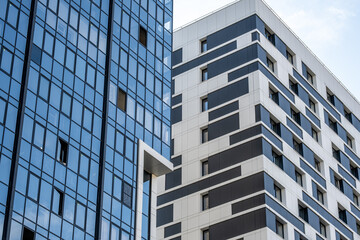 Two different high-rise buildings in the city next to each other.