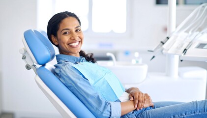 A focused woman with long brown hair sits comfortably in a modern office chair, surrounded by a tidy workspace filled with plants and a laptop.