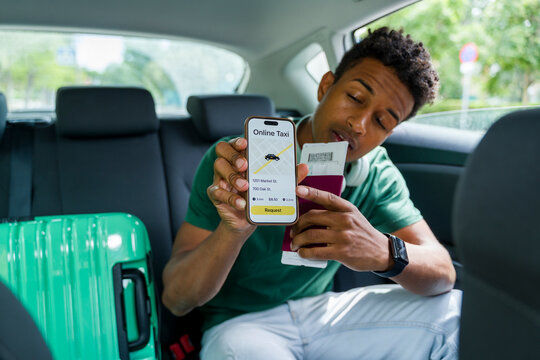 Tourist in car using taxi app and holding passport with luggage